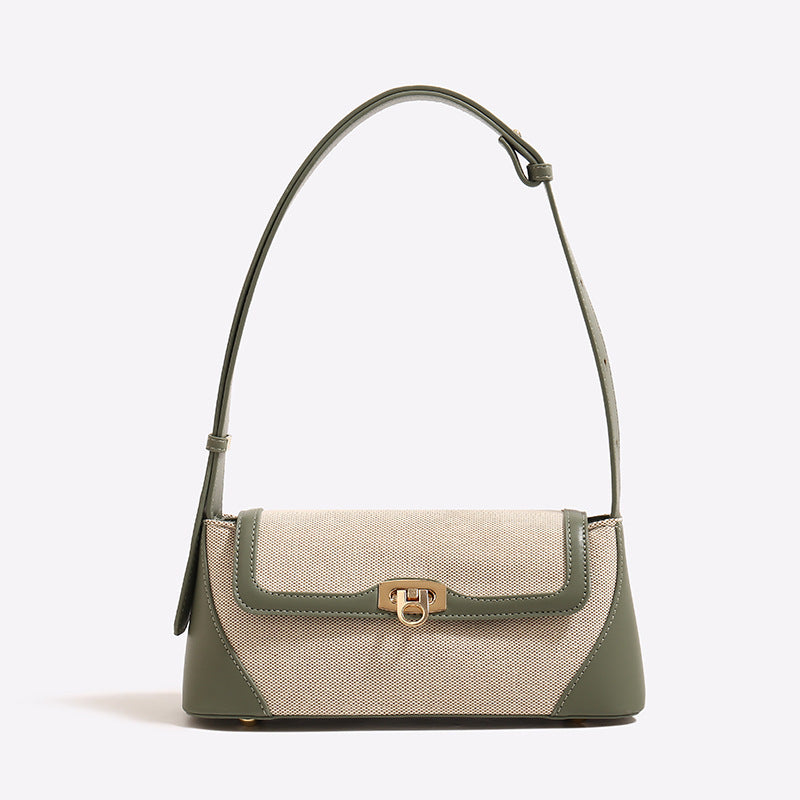 Structured trapezoid flap shoulder bag with canvas-textured body, smooth contrast trim, and gold-tone turn-lock clasp, detail