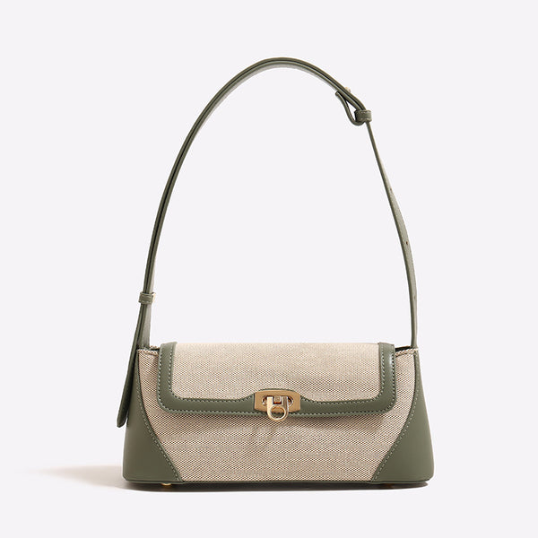 Structured trapezoid flap shoulder bag with canvas-textured body, smooth contrast trim, and gold-tone turn-lock clasp, detail