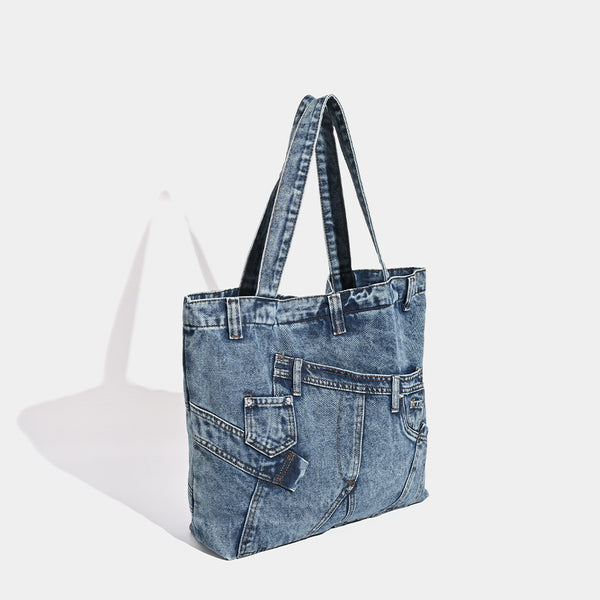 Large washed denim tote bag with jeans-style patch pocket and riveted seam detailing, double shoulder straps, open top