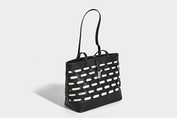Structured woven lattice cutout tote bag with smooth leather-look trim, dual shoulder straps, and silver-tone hardware