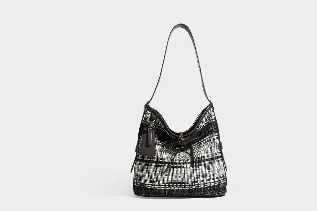 Schwarz-weiß karierte Hobo-Schultertasche aus gewebtem Material mit dunkelbrauner Einfassung in Lederoptik, Kordelzugverschluss und langem, verstellbarem