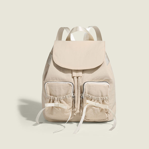 Soft matte nylon drawstring backpack with ruched bow-detail front zip pockets, top carry handle, and silver-tone hardware