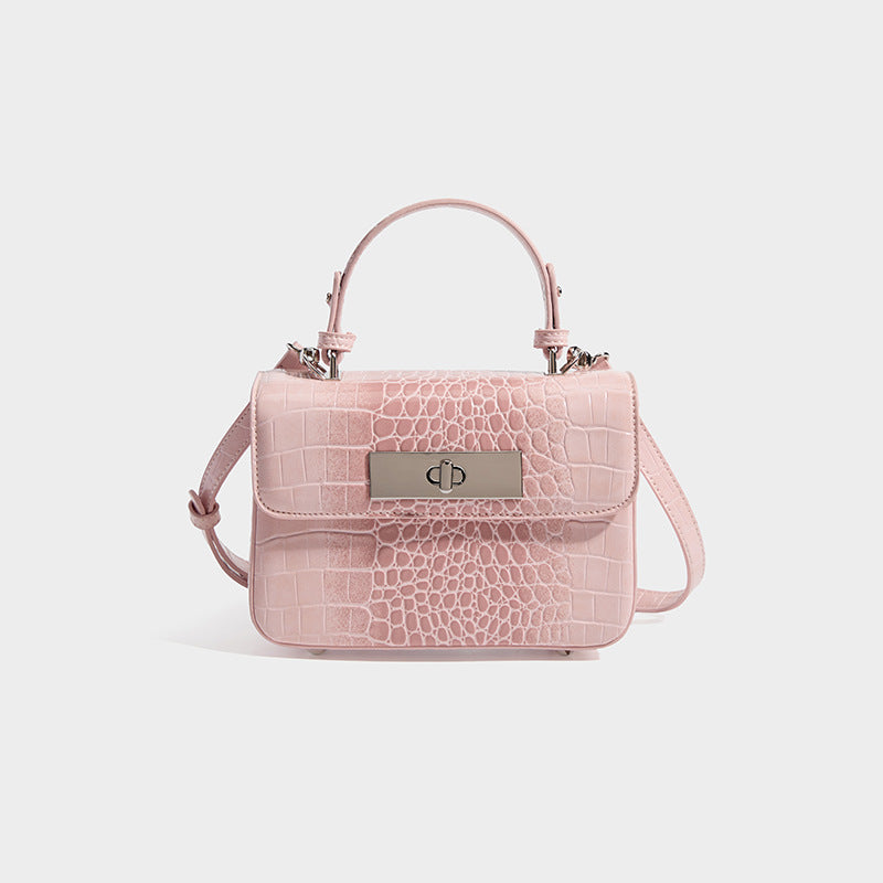 Small structured rectangular satchel with glossy crocodile-embossed finish, arched top handle, front flap, and silver-tone