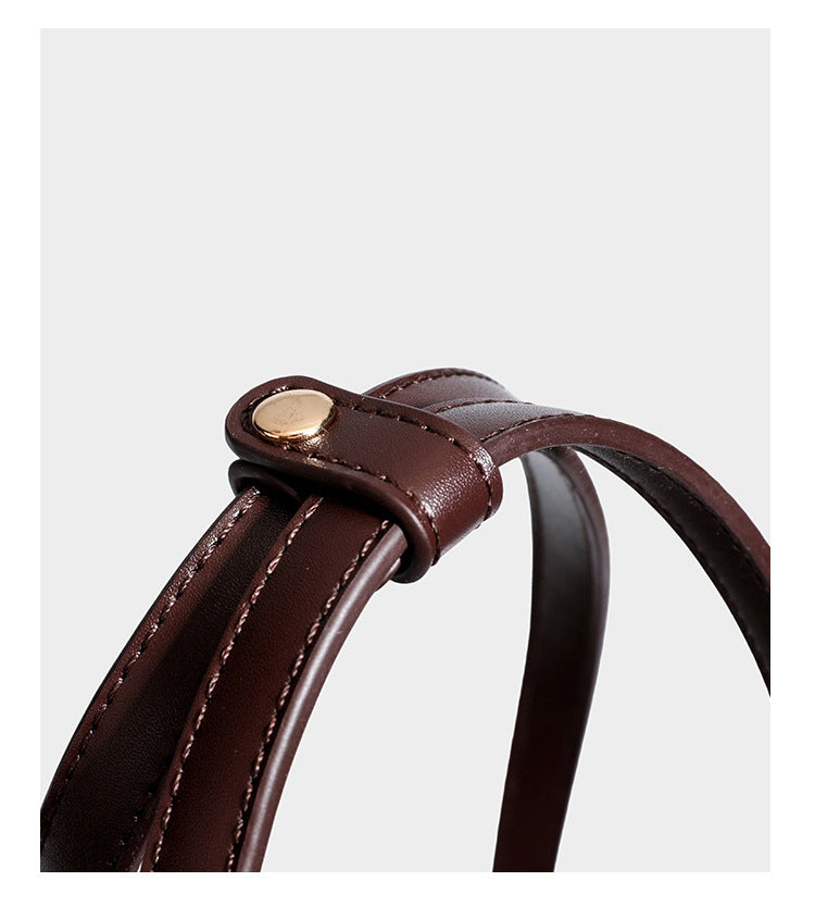 Structured trapezoid shoulder bag in dark brown pebbled leather-look finish with slim double straps, top zip closure, side