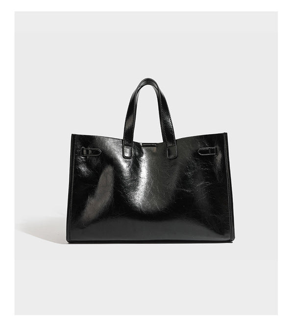 Strukturierte, glänzende Tote-Bag in Lederoptik mit silberfarbenem Drehverschluss, zwei Tragegriffen und abnehmbarem Schulterriemen, Detailansicht