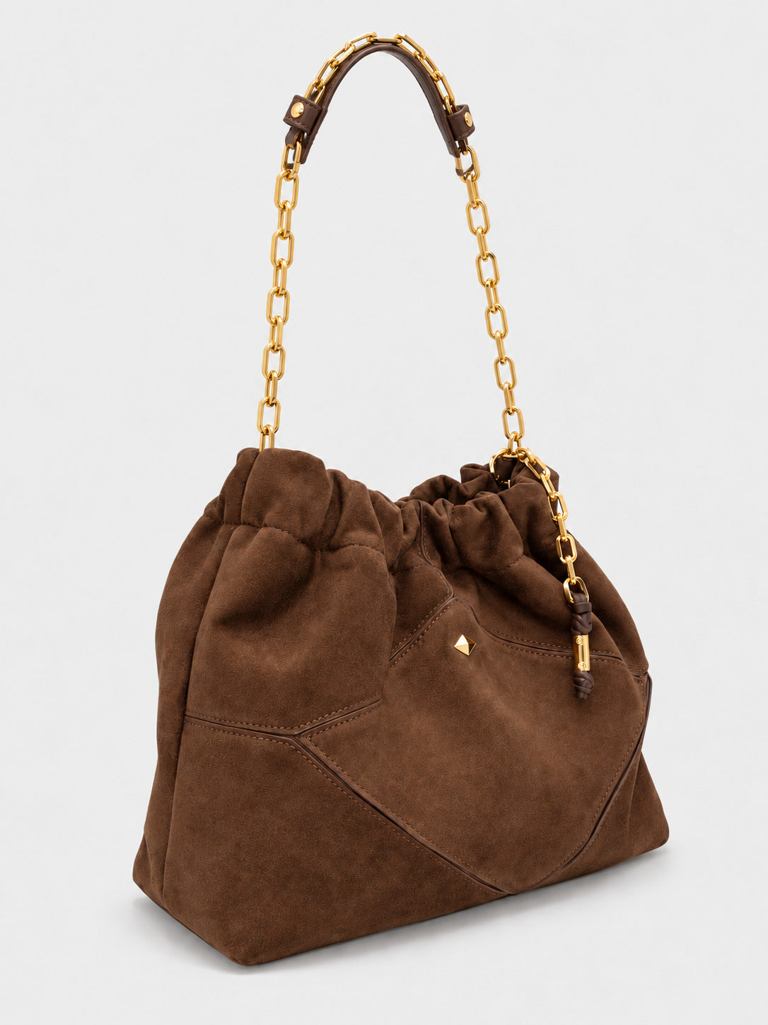 Slouchy suede-look shoulder bag with gathered top, angular stitched paneling, and chunky gold-tone chain strap, detail view