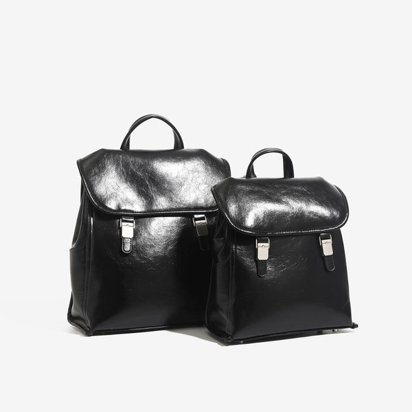 Structured glossy leather-look flap backpack handbag with dual buckle closures, top handle, and silver-tone hardware, front