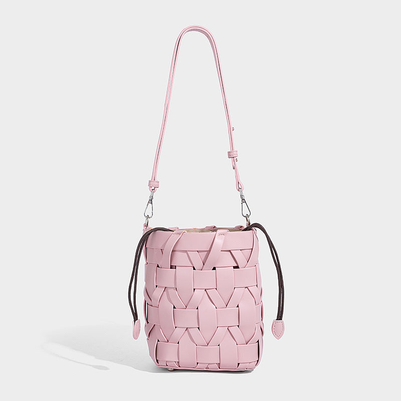 Small woven leather-look bucket bag with interlaced strip exterior, drawstring closure, and adjustable crossbody strap