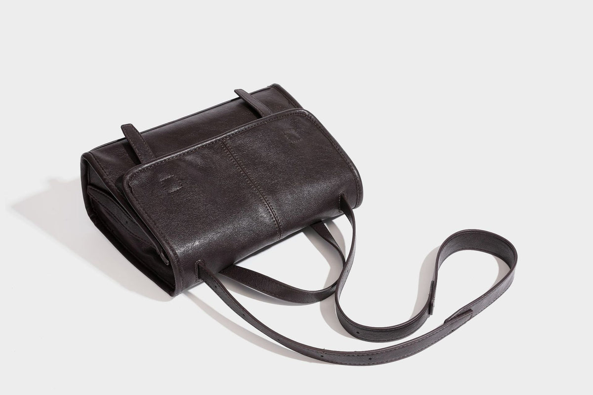 Strukturierte Satchel-Tasche mit Überschlag aus dunkelbrauner, glänzender Lederoptik, kurzem Tragegriff und langem, verstellbarem Schulterriemen