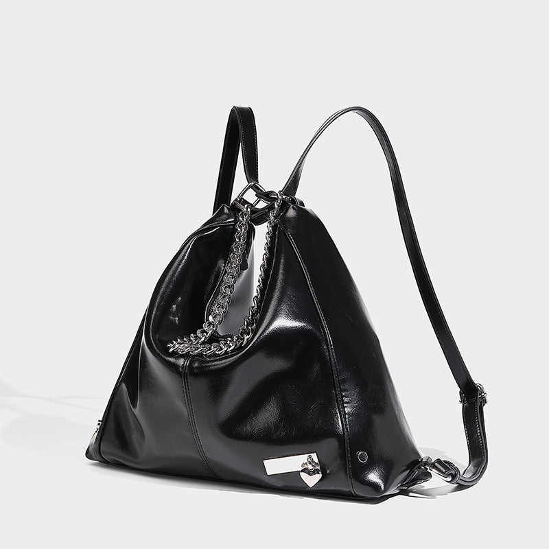 Glänzend schwarze, weich fallende Hobo-Tote-Bag mit silberfarbenem Kettenelement, Reißverschluss oben und langen Schulterriemen, Detailansicht 3