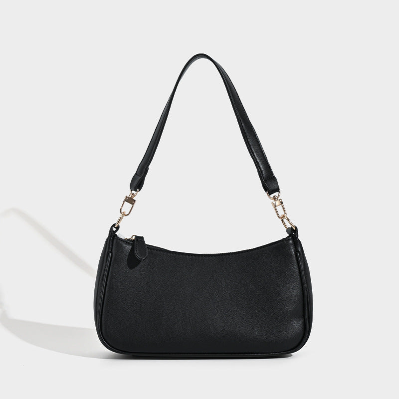 Compact arc-silhouette baguette shoulder bag with textured leather-look finish and gold-tone hardware, front view