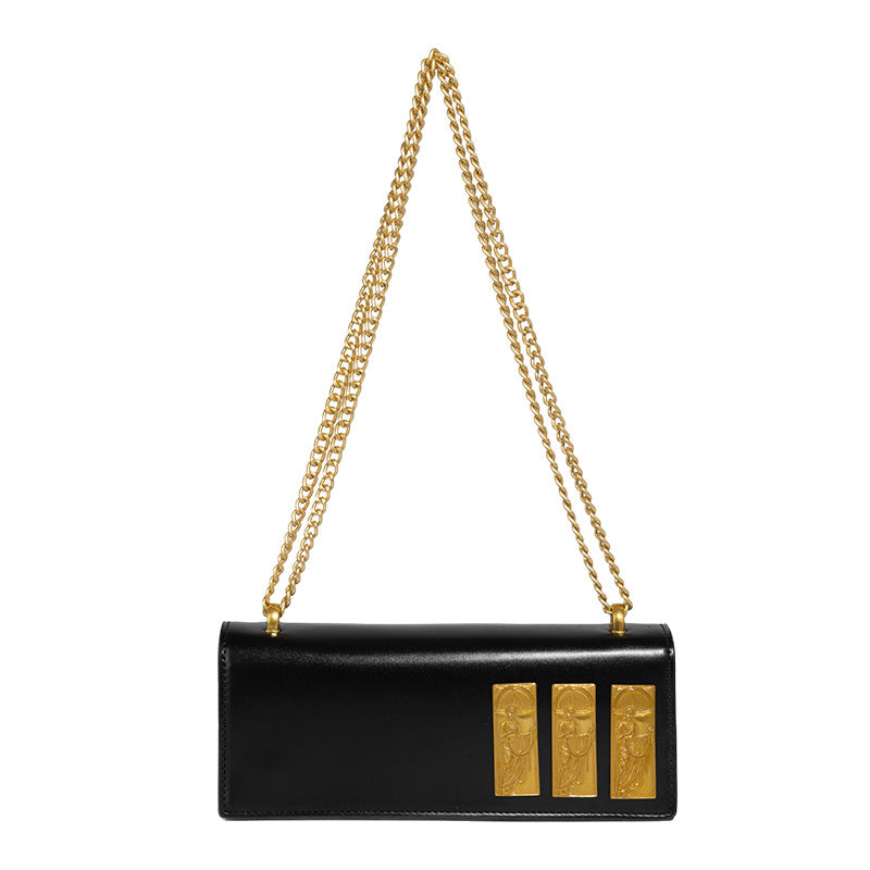 Structured rectangular crossbody bag with glossy finish, three vertical gold-tone embossed plaques, and gold chain strap