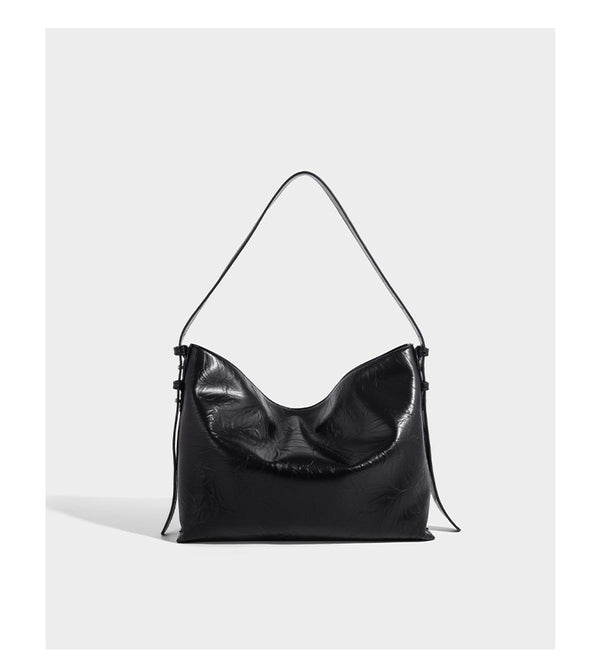 Large slouchy hobo shoulder bag in glossy crinkle leather-look finish with gold-tone emblem hardware and adjustable strap