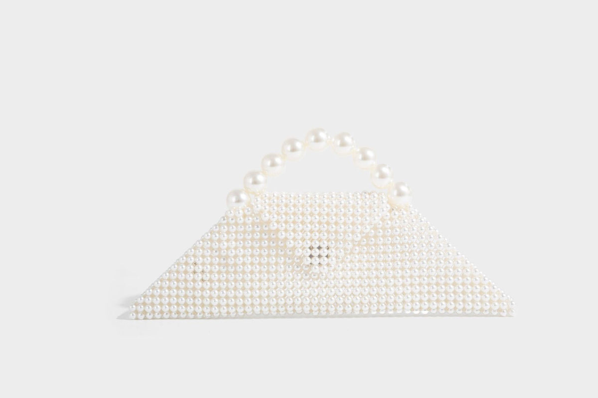 Small structured triangle clutch bag covered in glossy pearl beads with an arched pearl top handle and silver snap closure