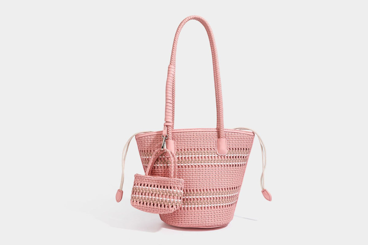 Light blue open-weave woven bucket tote bag with long braided shoulder straps, drawstring side ties, and attached mini pouch