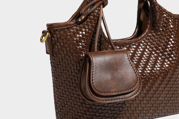 Woven leather-look tote bag in mocha brown with knotted top handle, front flap pocket, and detachable crossbody strap with