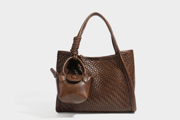 Strukturierte Tote-Bag mit Webstruktur in Braun, glattem, lederähnlichem Besatz, geknoteten Tragegriffen und einer befestigten Mini-Beuteltasche mit Kordelzug