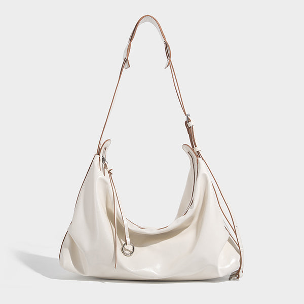 Glossy black slouchy hobo shoulder bag with zip closure, silver-tone ring hardware, and adjustable crossbody strap, detail