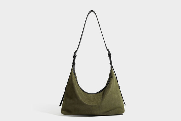 Slouchy olive green canvas hobo shoulder bag with black leather-look trim, zip-top closure, and adjustable strap, detail view