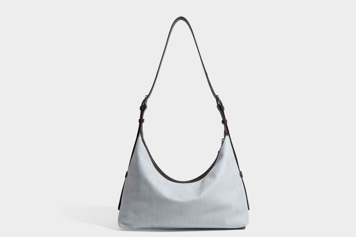 Slouchy olive green canvas hobo shoulder bag with black leather-look trim, zip-top closure, and adjustable strap, detail view