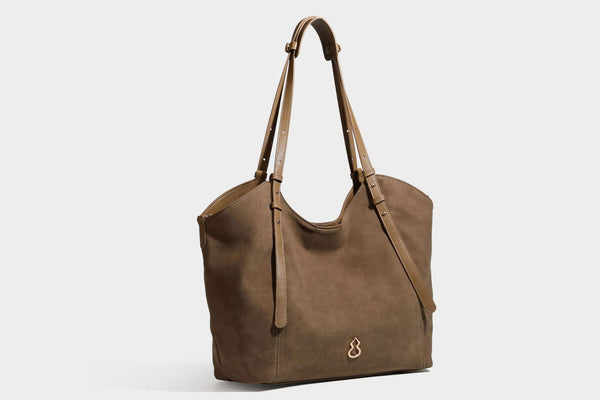 Oversized suede-finish tote shoulder bag in caramel brown with slim leather-look straps and gold-tone logo hardware, detail