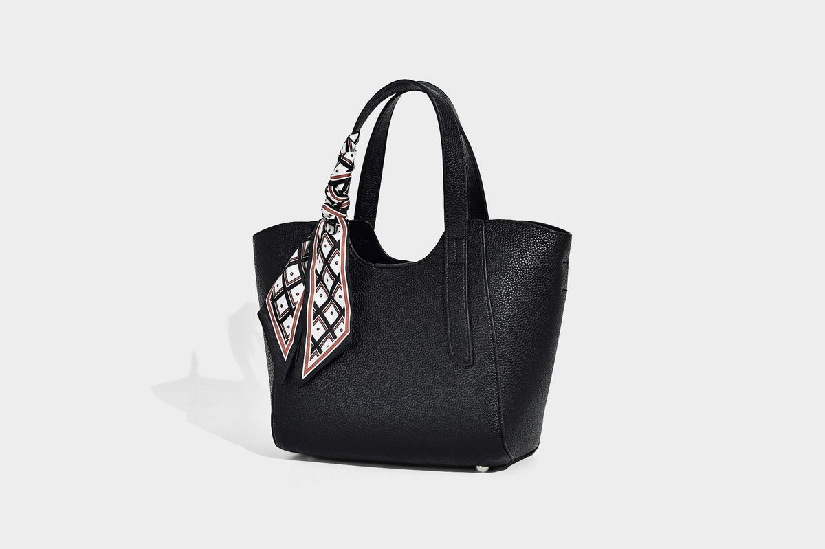 Structured pebbled leather-look tote bag with detachable scarf tie, dual top handles, and adjustable crossbody strap, detail