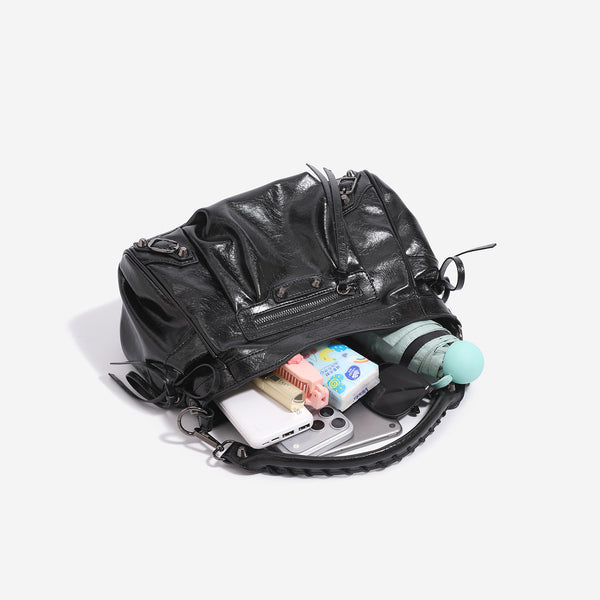 Slouchy glossy crinkle leather-look shoulder bag with silver stud accents, tassel ties, front zip pocket, and top handle