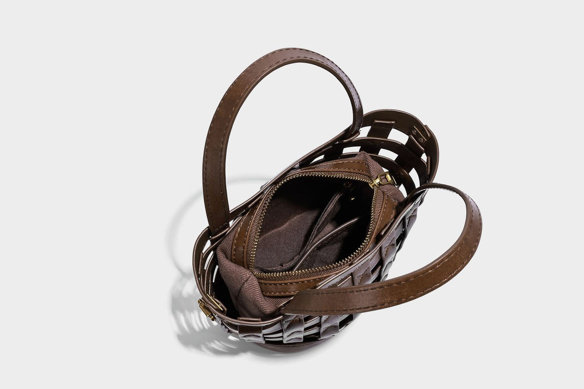 Small woven lattice bucket bag in brown leather-look finish with beaded tassel charm, dual top handles, and detachable