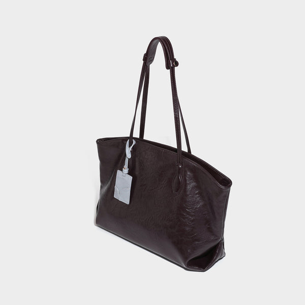 Oversized-Shopper mit lässig-weicher Form in dunkler Burgunderfarbe, glänzender geknautschter Lederoptik, zwei langen Schulterriemen und kontrastierendem
