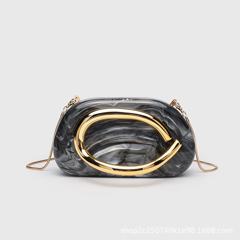 Kleine rechteckige Crossbody-Clutch mit abgerundeten Ecken, oversized poliertem C-förmigem Goldgriff und schmalem Goldkettenriemen, Detailansicht