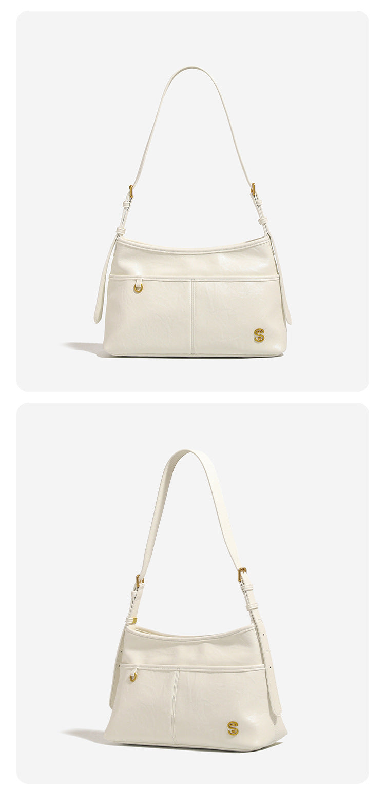 Relaxed leather-look shoulder tote bag in cream white with front exterior pocket, gold-tone ring hardware, and adjustable