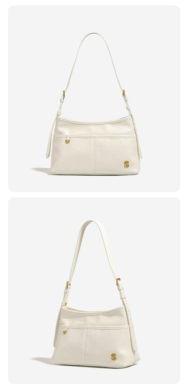 Relaxed leather-look shoulder tote bag in cream white with front exterior pocket, gold-tone ring hardware, and adjustable