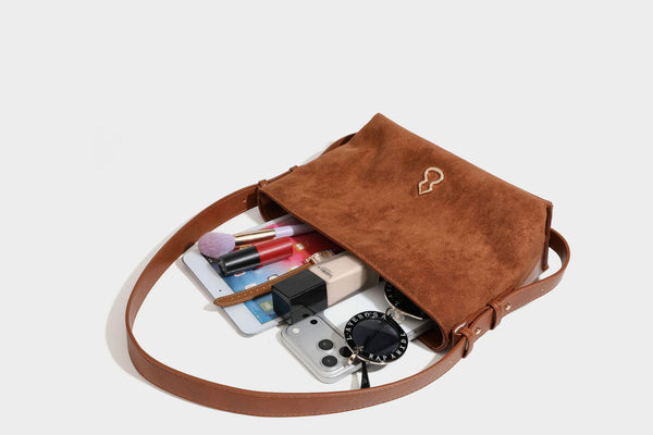 Slouchy suede-finish brown shoulder bag with long single strap and small gold-tone logo emblem on front, detail view 39