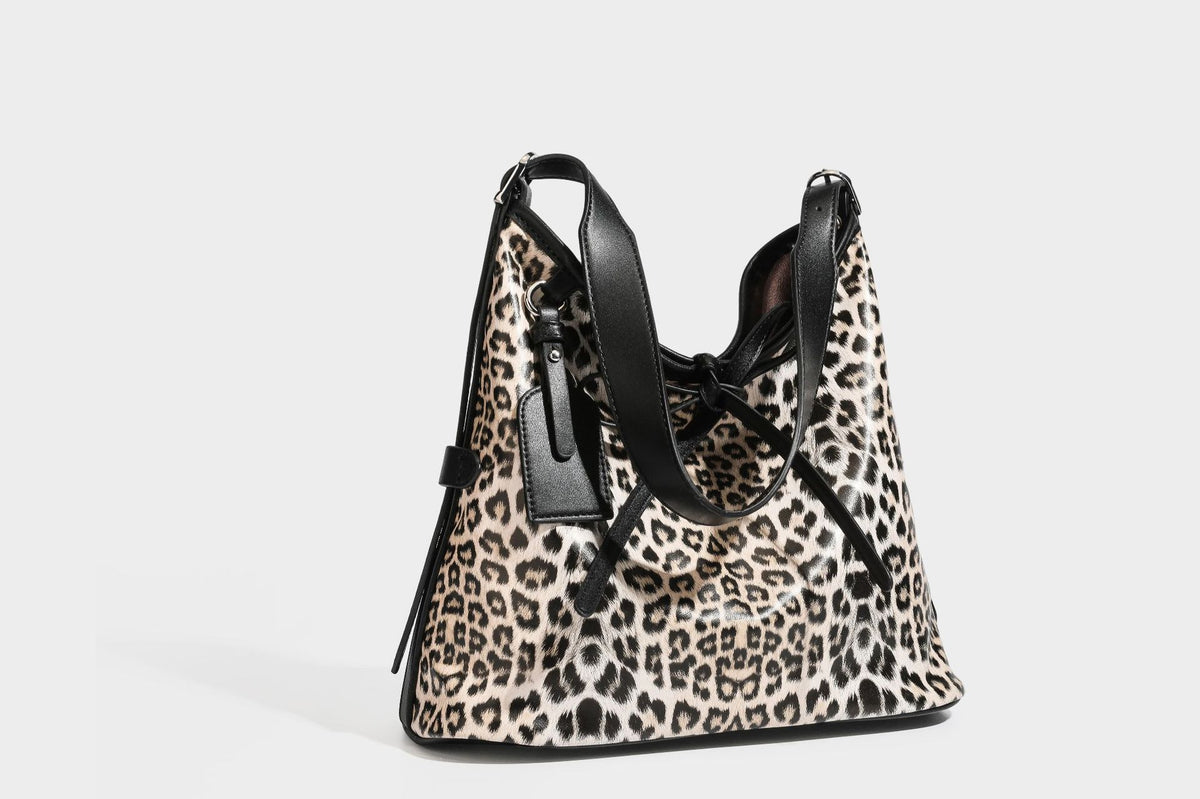 Slouchy leopard print shoulder hobo bag with black leather-look trim, tie-top closure, and single long strap, detail view 34