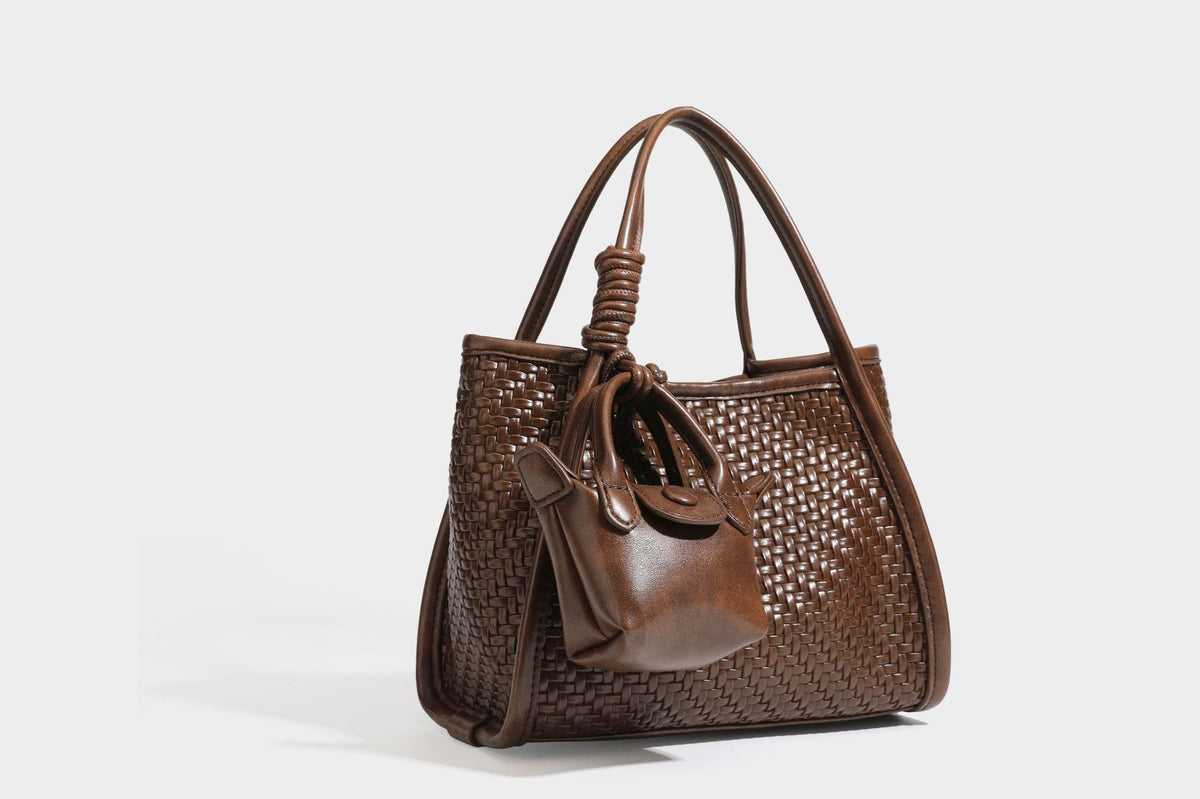 Strukturierte Tote-Bag mit Webstruktur in Braun, glattem, lederähnlichem Besatz, geknoteten Tragegriffen und einer befestigten Mini-Beuteltasche mit Kordelzug