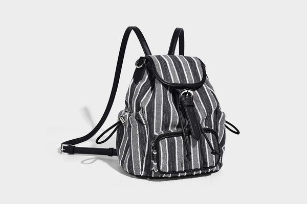 Weicher Rucksack aus gewebtem Material mit vertikalen Streifen, Überschlag, Kordelzug, vorderer Reißverschlusstasche, weißen Besätzen und Trägern in Lederoptik, Detailansicht