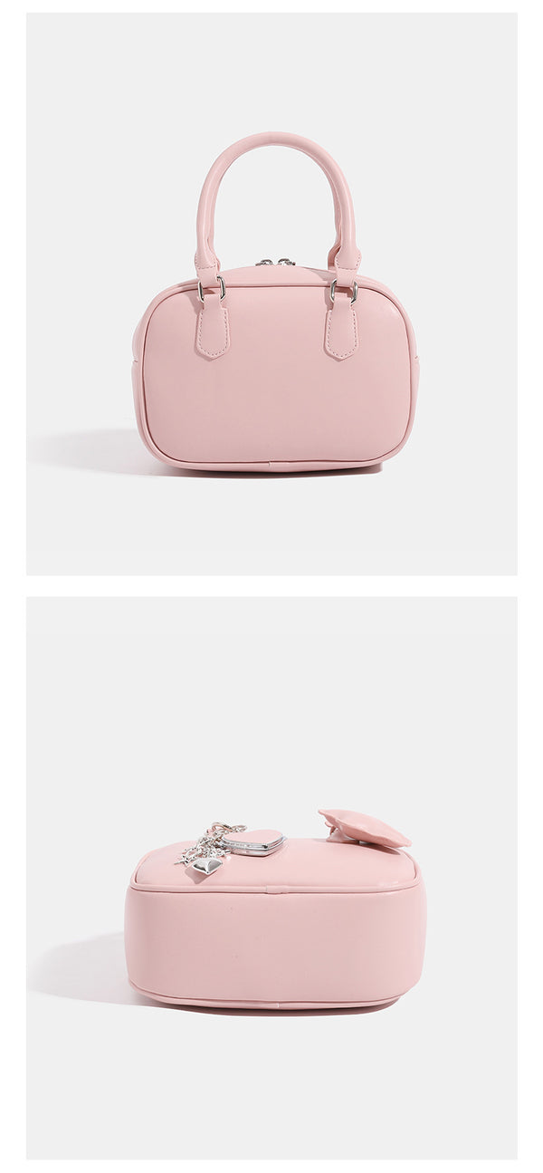 Small structured rounded-rectangle mini handbag with glossy leather-look finish, top zip closure, silver-tone hardware, and