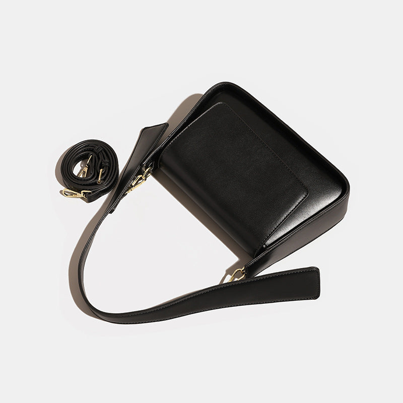 Strukturierte, rechteckige schwarze Schultertasche in Lederoptik mit Klappe, breitem flachem Riemen und goldfarbenen Drehbeschlägen, Detailansicht 4