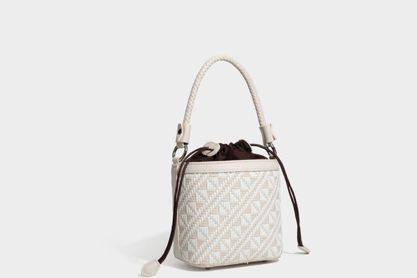Kleine gewebte geometrische Bucket-Bag mit geflochtenem Henkel in Lederoptik und Kordelzugverschluss im zweifarbigen Muster aus Braun und Weiß