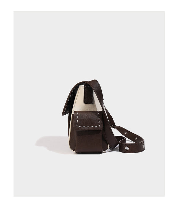 Structured flap crossbody bag in dark brown and cream color-block with white contrast stitching, adjustable shoulder strap