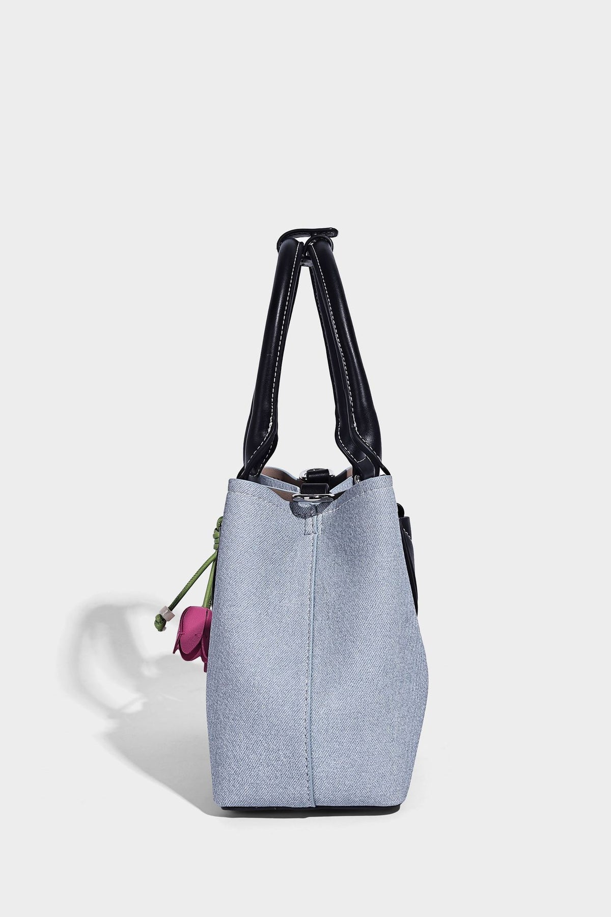 Structured light-blue denim-look tote bag with black leather-look handles, white contrast stitching, silver-tone hardware