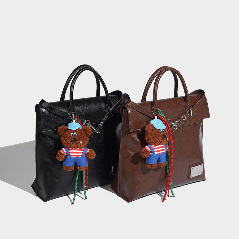 Large glossy leather-look convertible tote backpack with plush bear charm and silver hardware, detail view 2