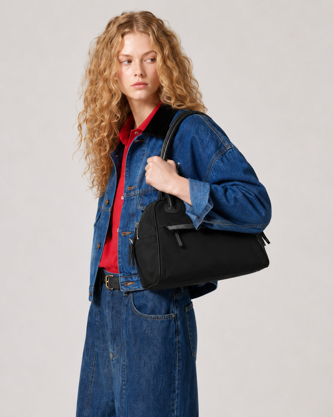 Structured dome top-handle bag in matte nylon with pebbled vegan leather-look trim, zip-top closure, front slip pocket, and