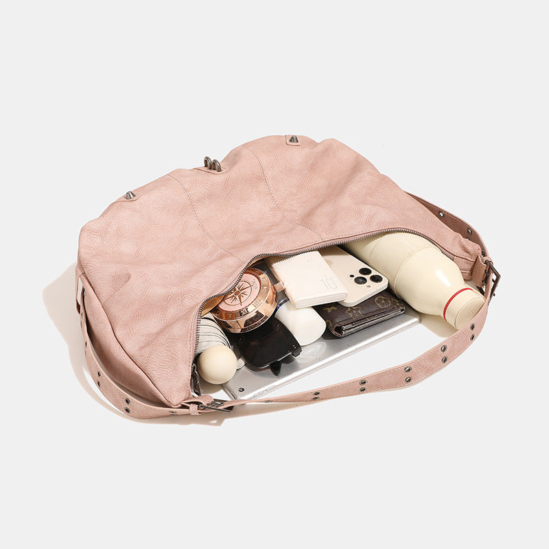 Crescent hobo shoulder bag in matte leather-look finish with star stud front panel, antique-silver hook hardware, and, detail