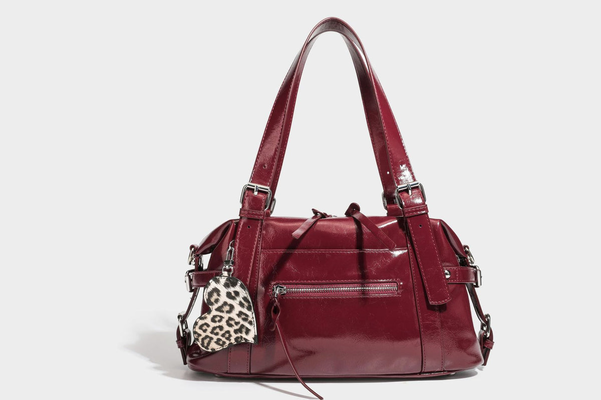 Strukturierte Schultertasche in glänzender Lederoptik mit abgerundetem Korpus, silberfarbenen Beschlägen, Reißverschlussfach auf der Vorderseite und Leopardenmuster