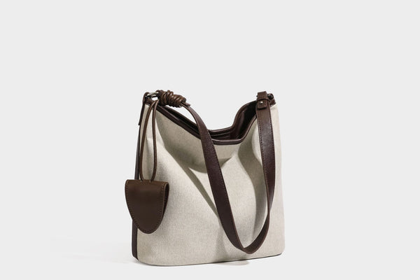 Oatfarbene Canvas-Schultertasche mit dunkelbraunem Besatz in Lederoptik, langem verstellbarem Riemen und angebrachter Mini-Tasche mit Überschlag, Detailansicht