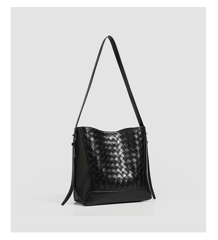 Large black bucket shoulder bag with diamond woven leather-look front panel, smooth side panels, magnetic snap closure, and