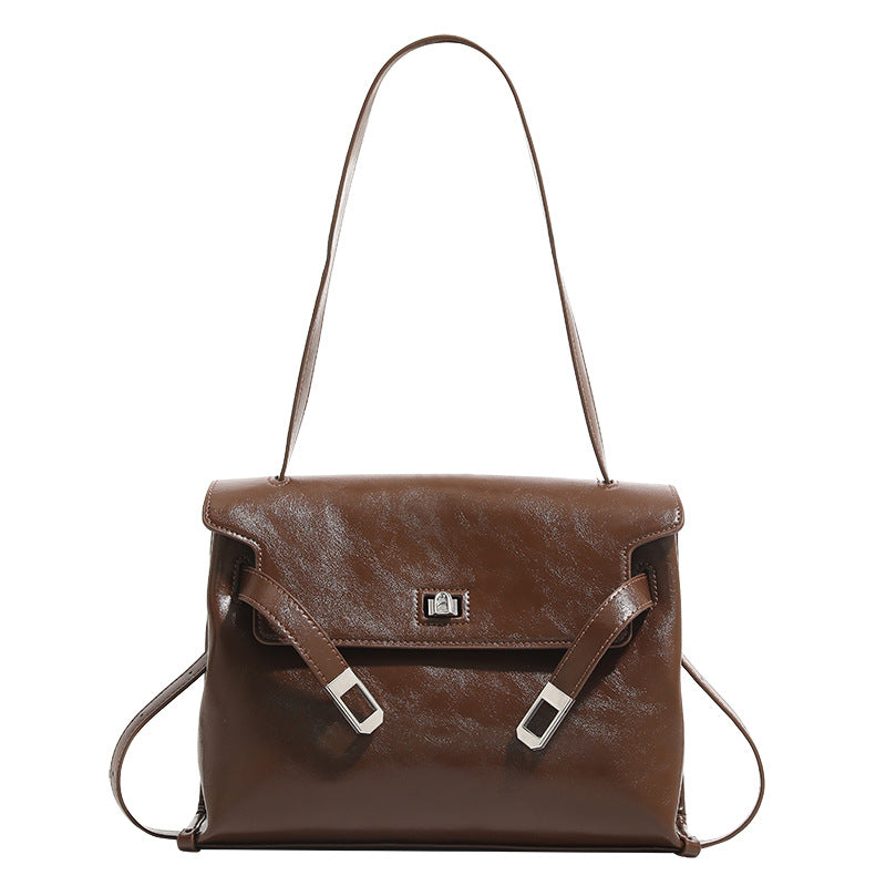 Structured rectangular flap shoulder bag in glossy leather-look finish with silver turn-lock clasp and adjustable strap