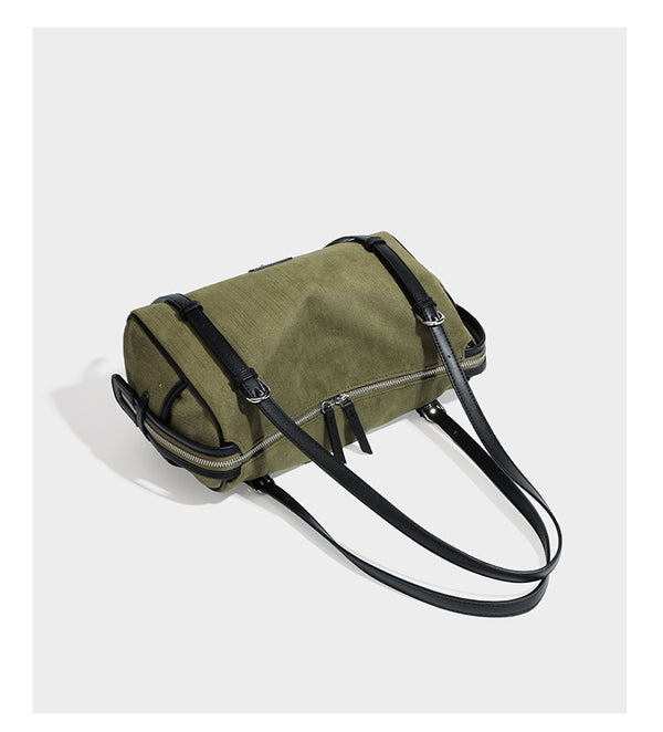 Olivgrüne Schultertasche in Zylinderform aus Canvas mit Riemen in schwarzer Lederoptik, Reißverschluss oben und silberfarbenen Beschlägen, Detailansicht