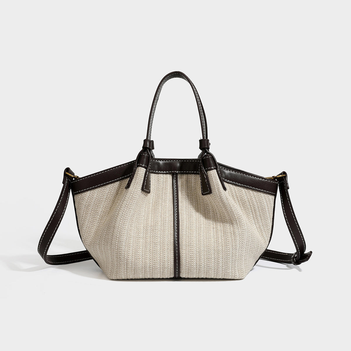Cremefarbene gewebte Tote-Bag mit dunkelbraunem Besatz in Lederoptik, weißen Kontrastnähten, zwei Tragegriffen und abnehmbarem Schulter